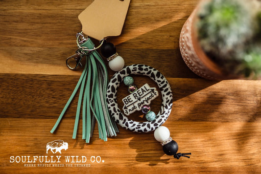 Wild Soul Keychain - Silicone Circle Cow Print "Be Real, Not Perfect"